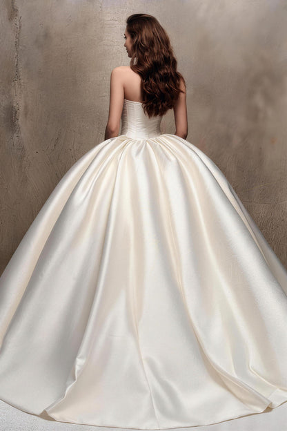 Fitted white satin wedding gown with ruching and a voluminous skirt.
